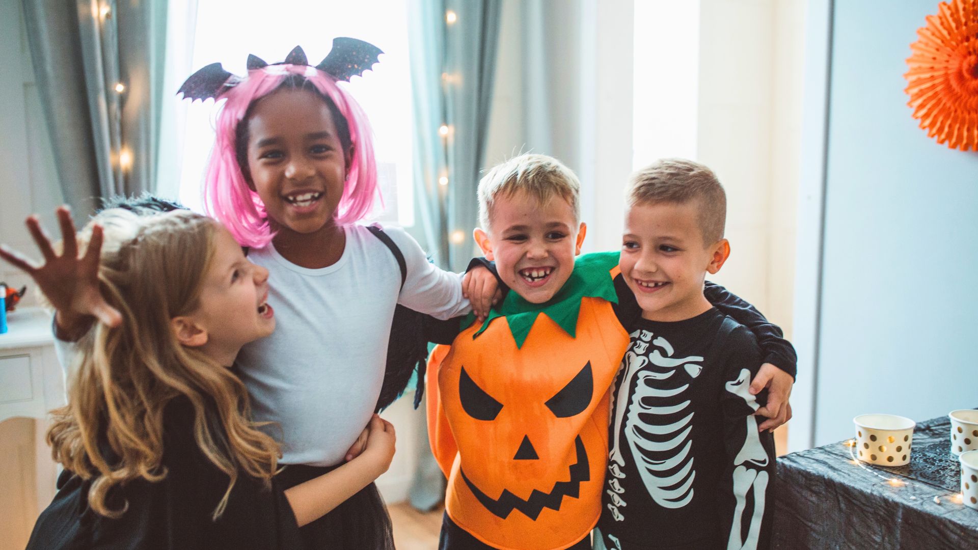kids in costume hugging at a halloween party