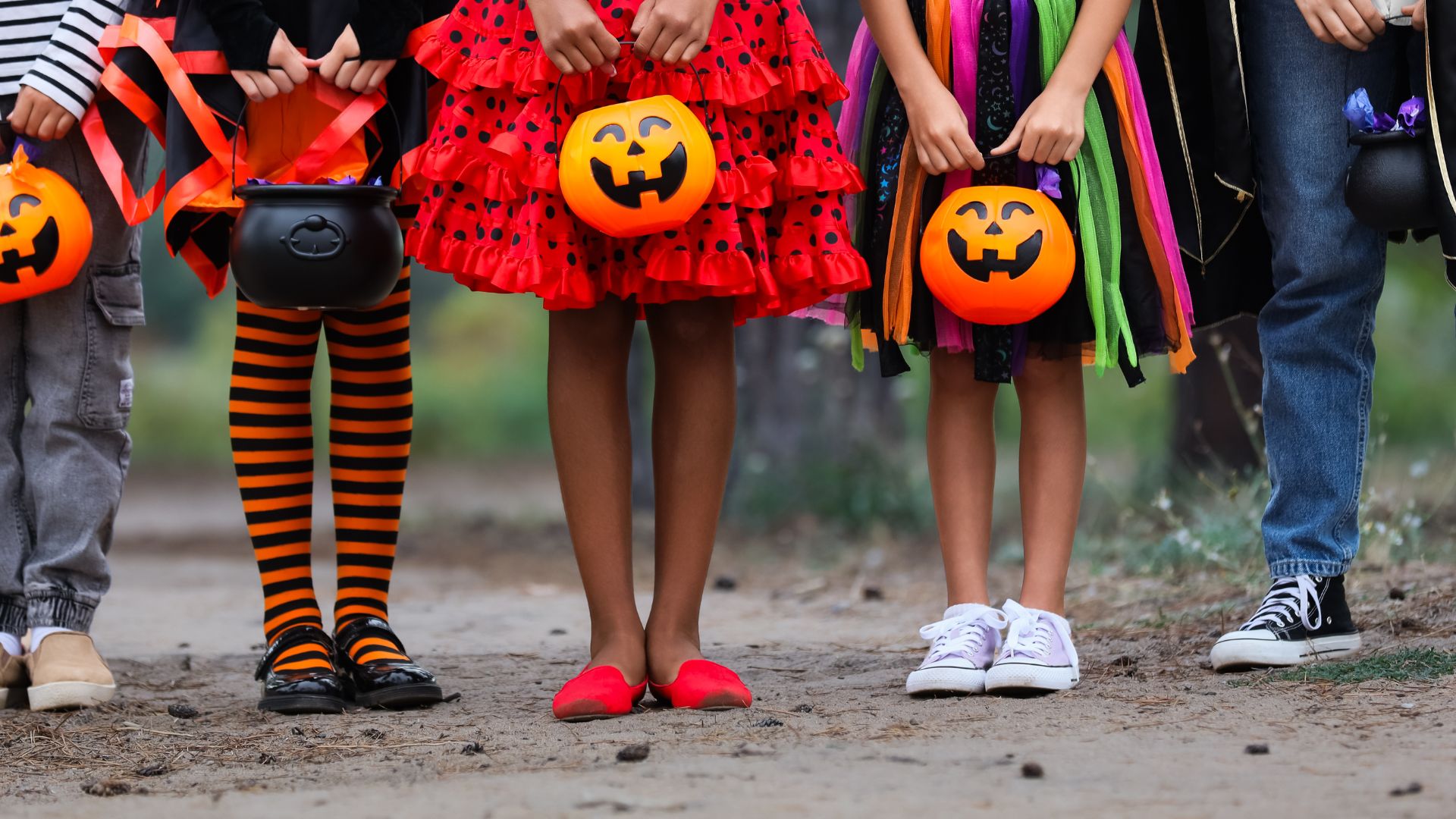 children in costume holding halloween pails